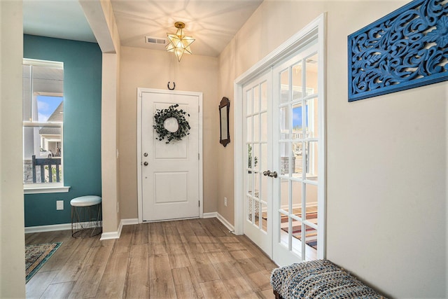 entryway featuring visible vents, baseboards, wood finished floors, and french doors