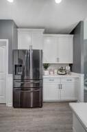 kitchen featuring white cabinetry, light countertops, and stainless steel fridge with ice dispenser