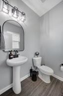 bathroom featuring toilet, baseboards, and wood finished floors