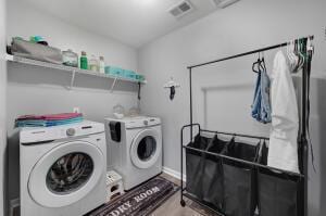 laundry area with visible vents, light wood-style floors, laundry area, and washer and clothes dryer