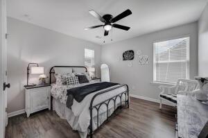 bedroom with multiple windows, ceiling fan, baseboards, and wood finished floors