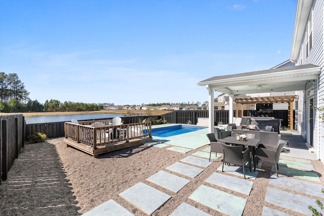 view of swimming pool with a fenced in pool, a fenced backyard, a ceiling fan, a deck with water view, and a patio