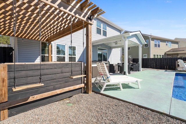 view of patio featuring a swimming pool, a pergola, and fence