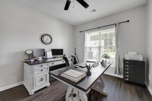 home office with baseboards, dark wood-type flooring, a ceiling fan, and vaulted ceiling