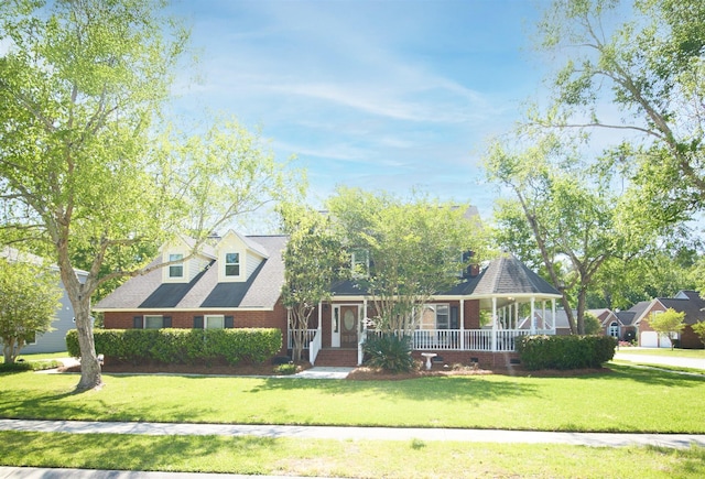 cape cod-style house with covered porch, a front yard, and brick siding