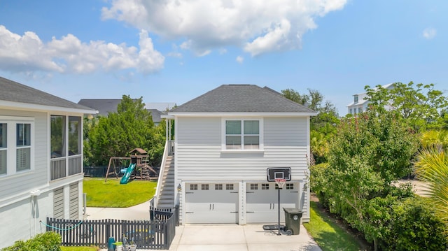 1722 Trewin Ct, Charleston, SC 29492 - view of side of home featuring a garage, concrete driveway, a playground, and roof with shingles