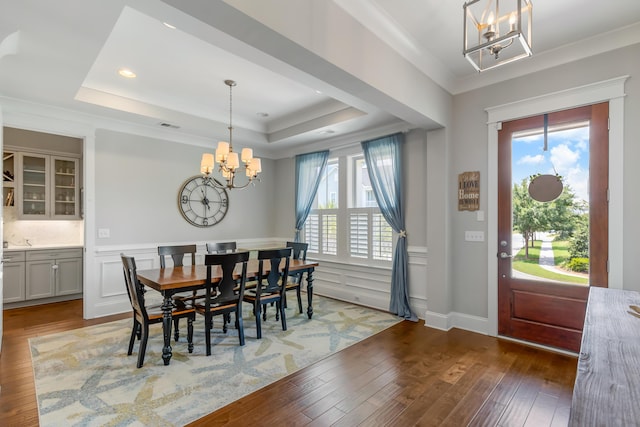 1722 Trewin Ct, Charleston, SC 29492 - dining room with a chandelier, a tray ceiling, light wood-type flooring, a wainscoted wall, and crown molding