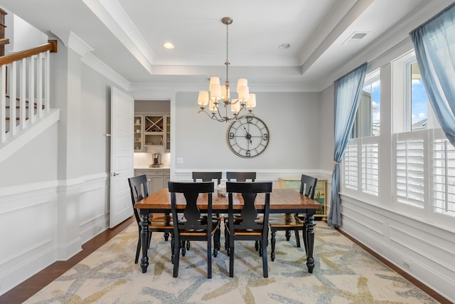1722 Trewin Ct, Charleston, SC 29492 - dining area featuring a raised ceiling, a chandelier, stairway, wainscoting, and wood finished floors