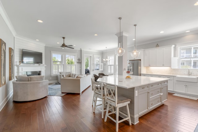1722 Trewin Ct, Charleston, SC 29492 - kitchen featuring high quality fridge, a kitchen bar, white cabinetry, a fireplace, and ornamental molding
