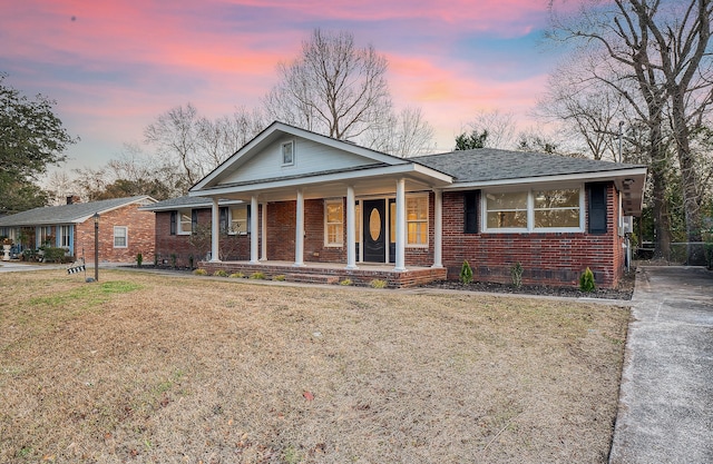 view of front of property with a porch and a yard