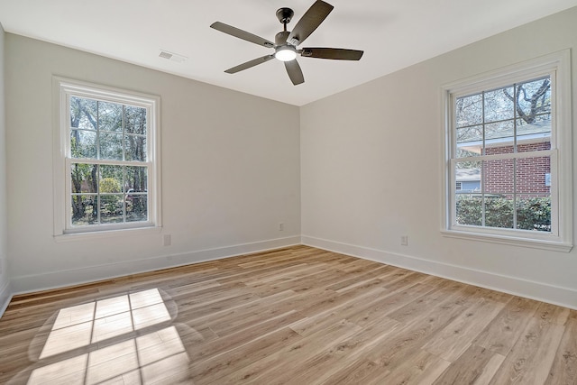 empty room with light hardwood / wood-style flooring, plenty of natural light, and ceiling fan