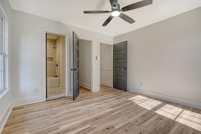 unfurnished bedroom featuring ensuite bathroom, ceiling fan, and light hardwood / wood-style flooring