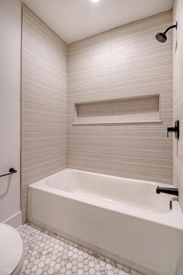 bathroom with tiled shower / bath and toilet