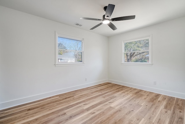 empty room featuring plenty of natural light, light hardwood / wood-style floors, and ceiling fan