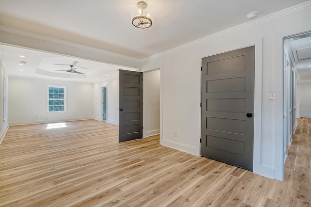 foyer entrance with crown molding, a raised ceiling, ceiling fan, and light wood-type flooring