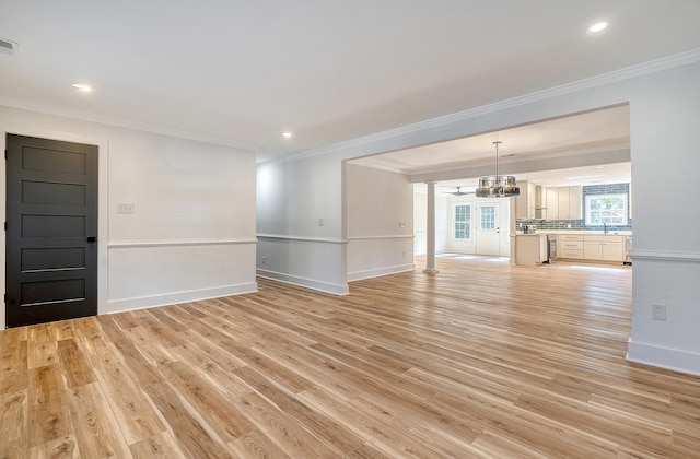 unfurnished living room featuring ornamental molding and light hardwood / wood-style flooring