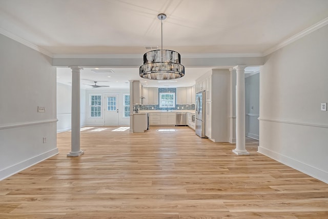 unfurnished living room with crown molding, ceiling fan, light wood-type flooring, and ornate columns