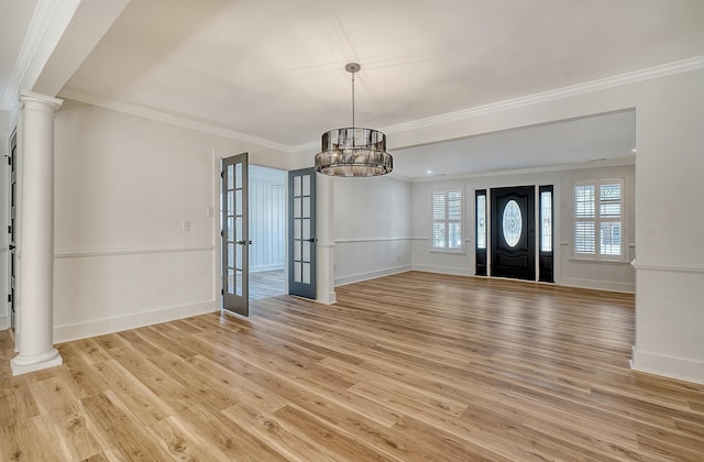 entrance foyer with decorative columns, ornamental molding, and light hardwood / wood-style flooring