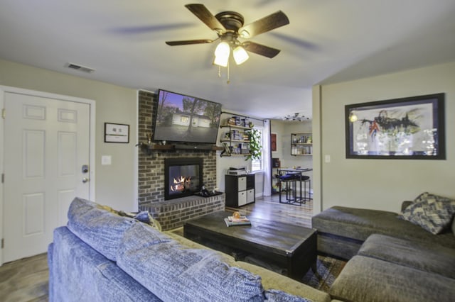 living room featuring ceiling fan and a fireplace