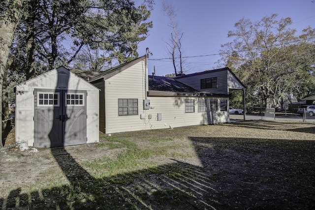 rear view of property featuring a shed