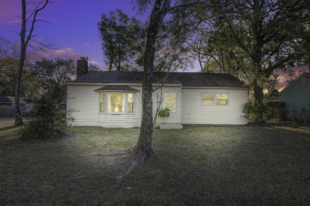 property exterior at dusk featuring a yard