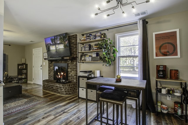 dining space featuring hardwood / wood-style floors and a fireplace