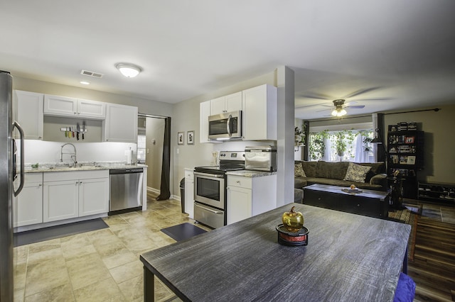 kitchen featuring white cabinets, light stone countertops, sink, and stainless steel appliances