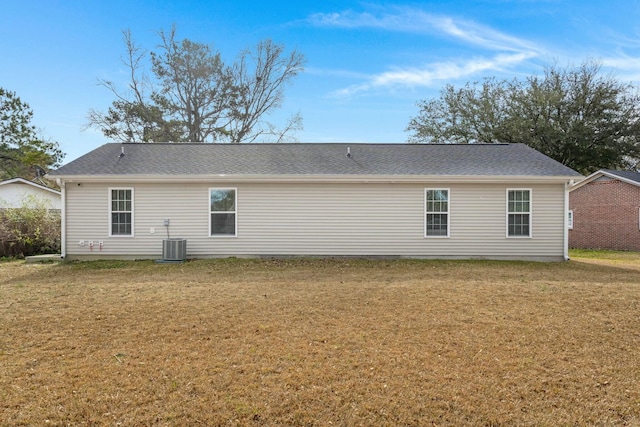 rear view of house featuring a lawn and central AC