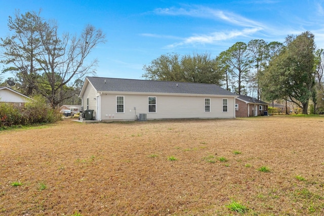 rear view of property with a yard and central AC unit