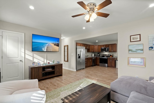 living room with ceiling fan and light hardwood / wood-style floors