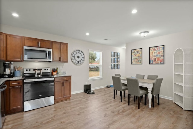 kitchen featuring light stone counters, light hardwood / wood-style flooring, and appliances with stainless steel finishes