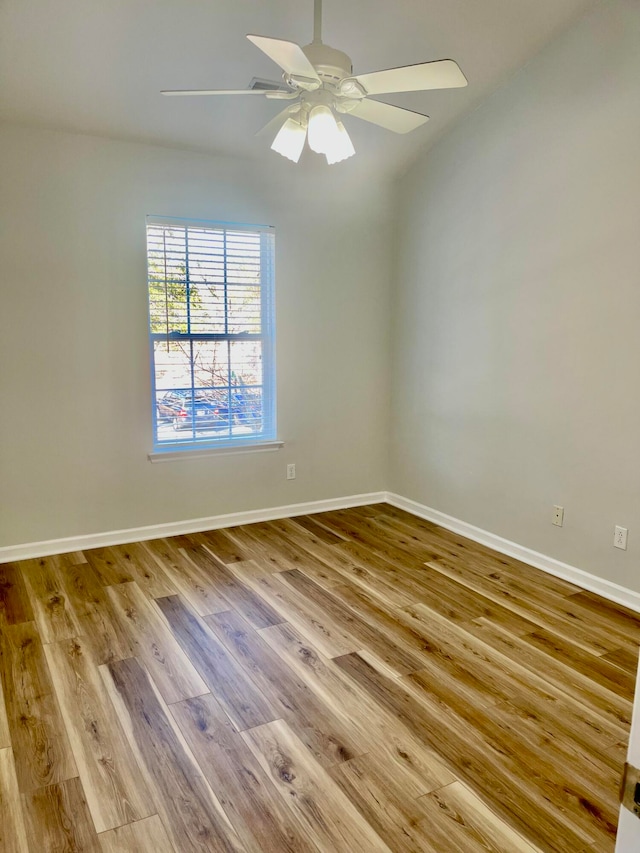 unfurnished room with ceiling fan, vaulted ceiling, and wood-type flooring