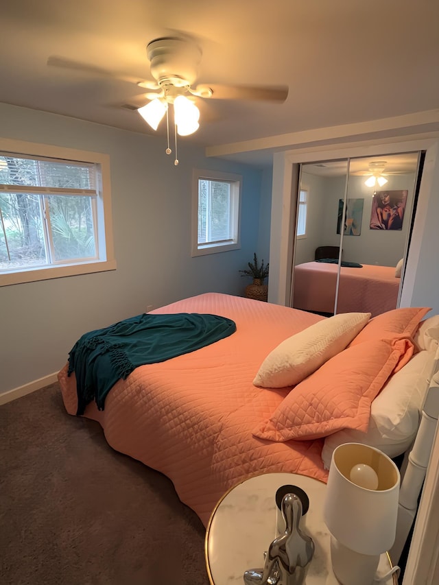 carpeted bedroom with ceiling fan, multiple windows, and a closet