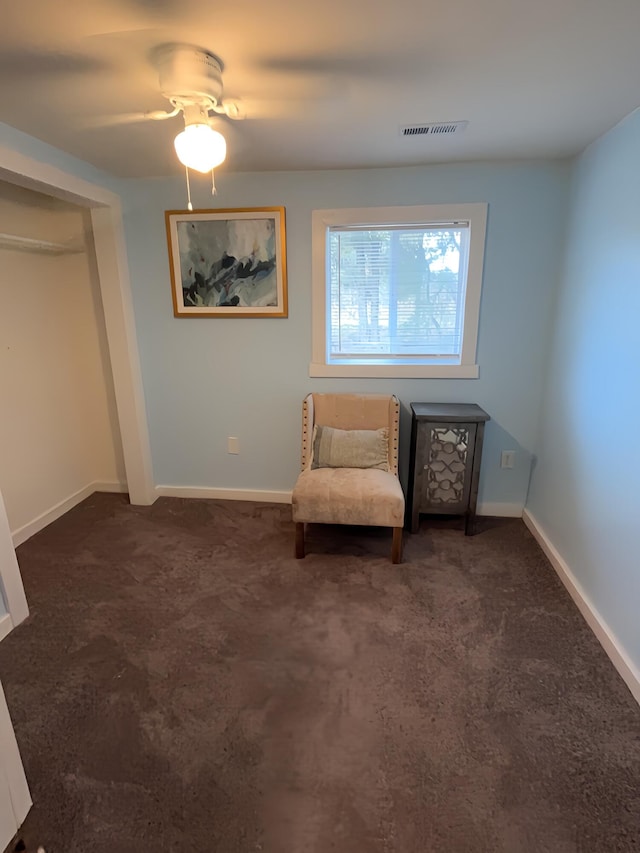 unfurnished room featuring ceiling fan and dark colored carpet