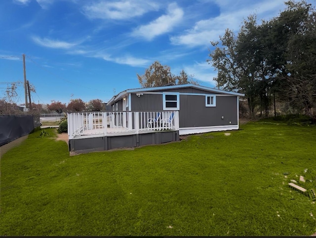 rear view of property with a lawn and a wooden deck