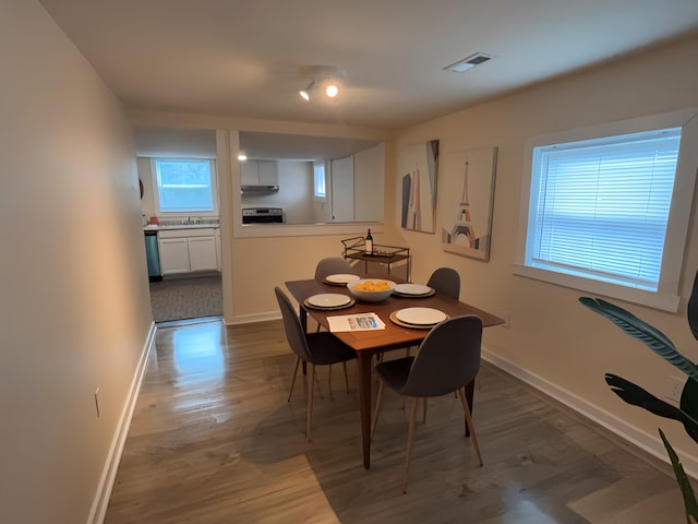 dining space with sink and hardwood / wood-style flooring