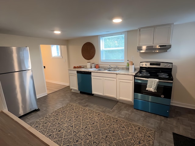 kitchen with dark parquet flooring, white cabinetry, sink, and stainless steel appliances