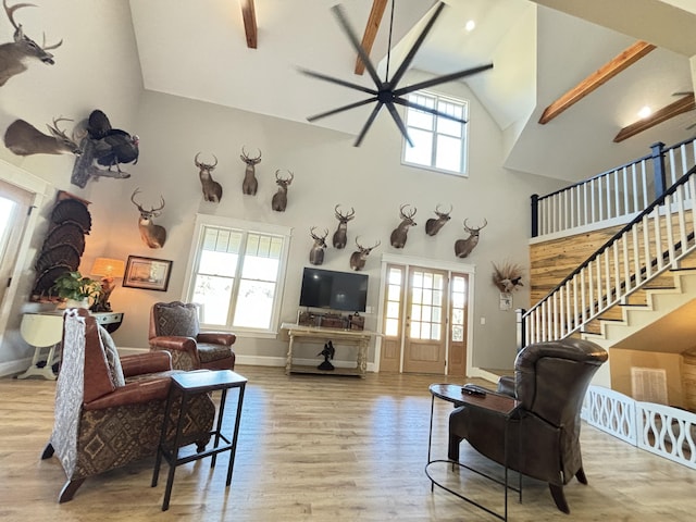 living room with light wood-type flooring, high vaulted ceiling, and plenty of natural light