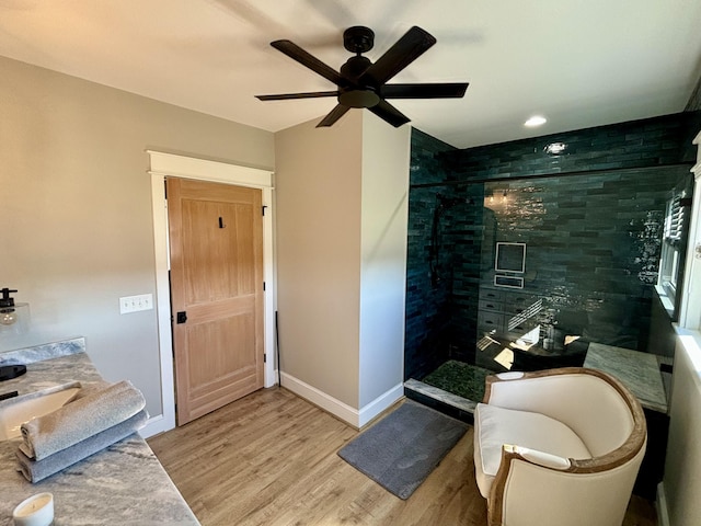 bathroom featuring vanity, ceiling fan, wood-type flooring, and a shower with door