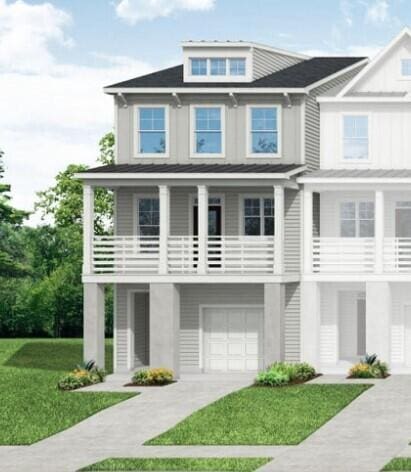 view of front facade with a front yard, a balcony, an attached garage, and driveway