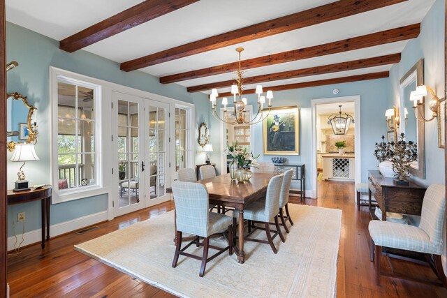 dining area with wood-type flooring, a notable chandelier, beam ceiling, and french doors