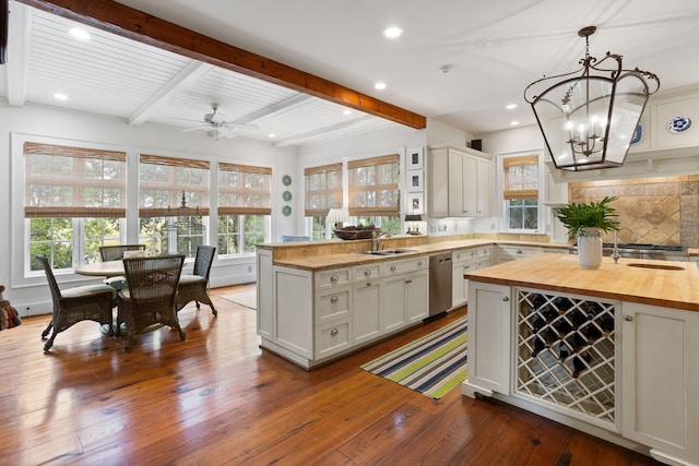 kitchen with butcher block counters, tasteful backsplash, dark hardwood / wood-style flooring, pendant lighting, and beam ceiling