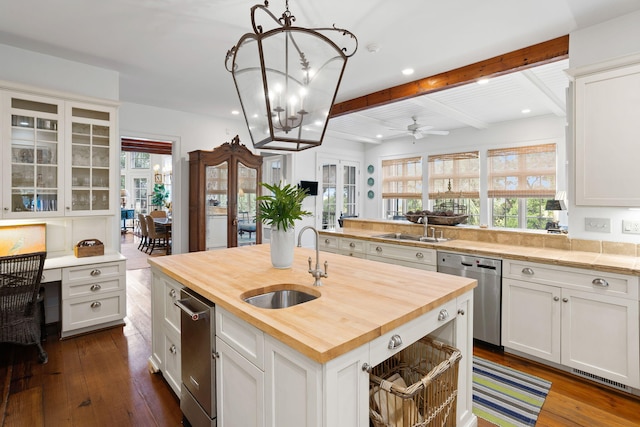 kitchen with sink, wooden counters, a kitchen island with sink, white cabinetry, and stainless steel dishwasher