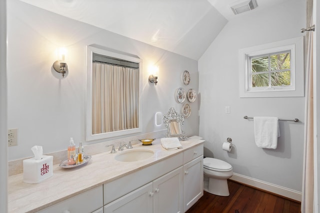 bathroom with vanity, toilet, vaulted ceiling, and hardwood / wood-style floors