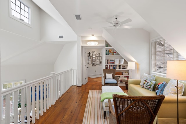 living area with hardwood / wood-style flooring, built in features, and ceiling fan