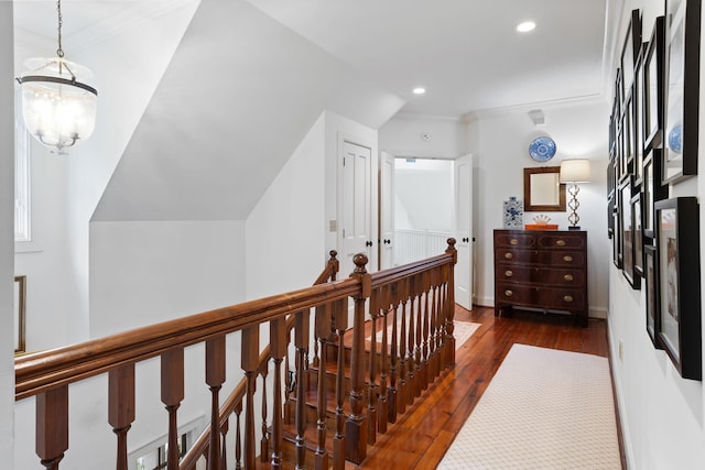 corridor with dark hardwood / wood-style flooring, a notable chandelier, and ornamental molding