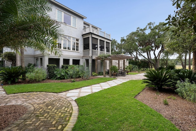 view of yard with a patio area, a balcony, a sunroom, and a pergola