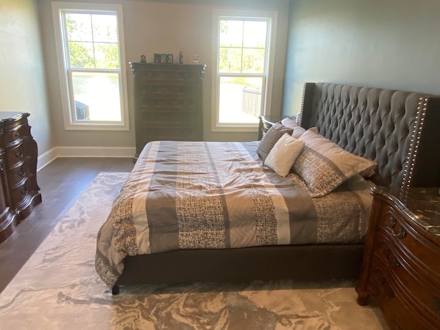 bedroom with multiple windows and dark wood-type flooring