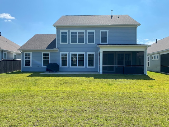 back of property featuring a lawn and a sunroom