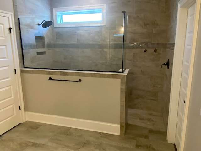 bathroom featuring a tile shower and tile patterned floors